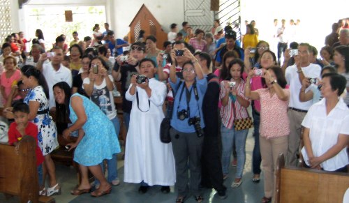 Family and friends quickly try to get photos of their loved ones after the ordination
