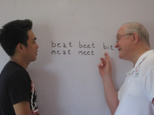 Fr. Bernie helps a student with pronunciation drills