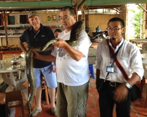 Fr. Wayne, told that the snake is "used to people," gets up close and personal with a python